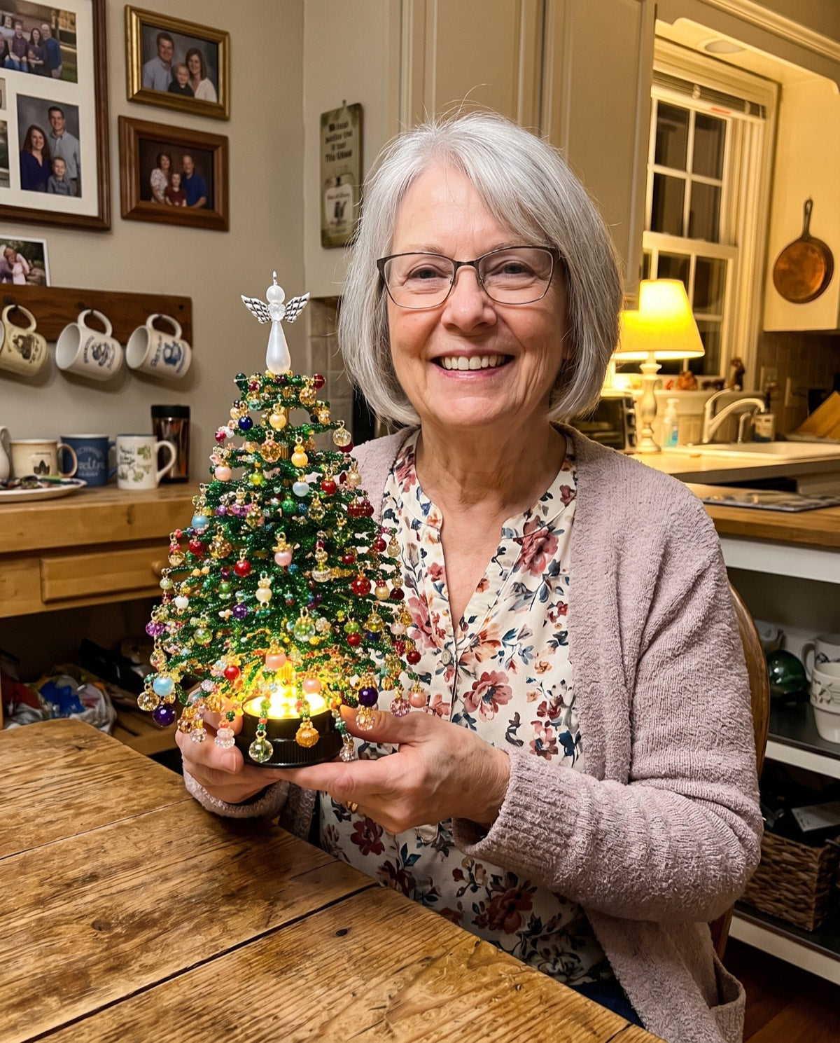 A finished beaded tree held up beside the table it was built on